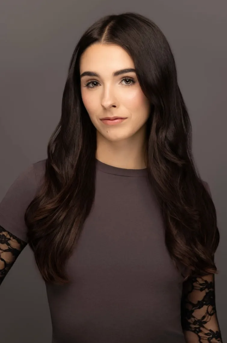 Elisabeth Fitzgerald, headshot in a charcoal top with lace sleeves, looking directly at the camera