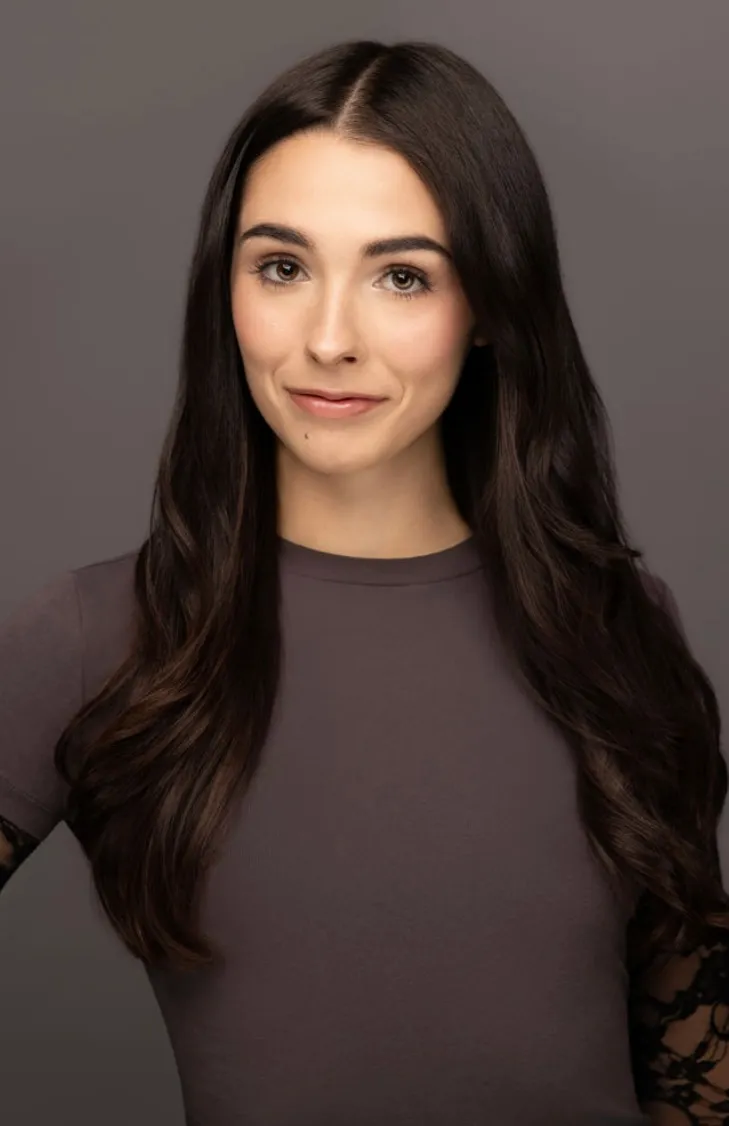 Elisabeth Fitzgerald, headshot in a charcoal top on a grey backdrop, a slight smile